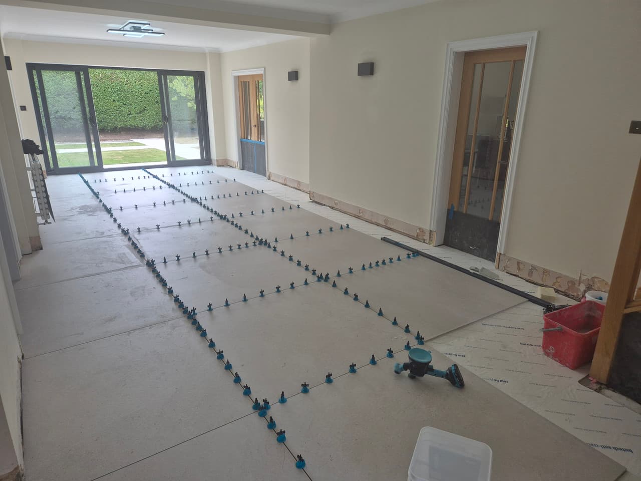 1200 x 1200 porcelain tiling progressing across the main floor with a grid of levelling clips