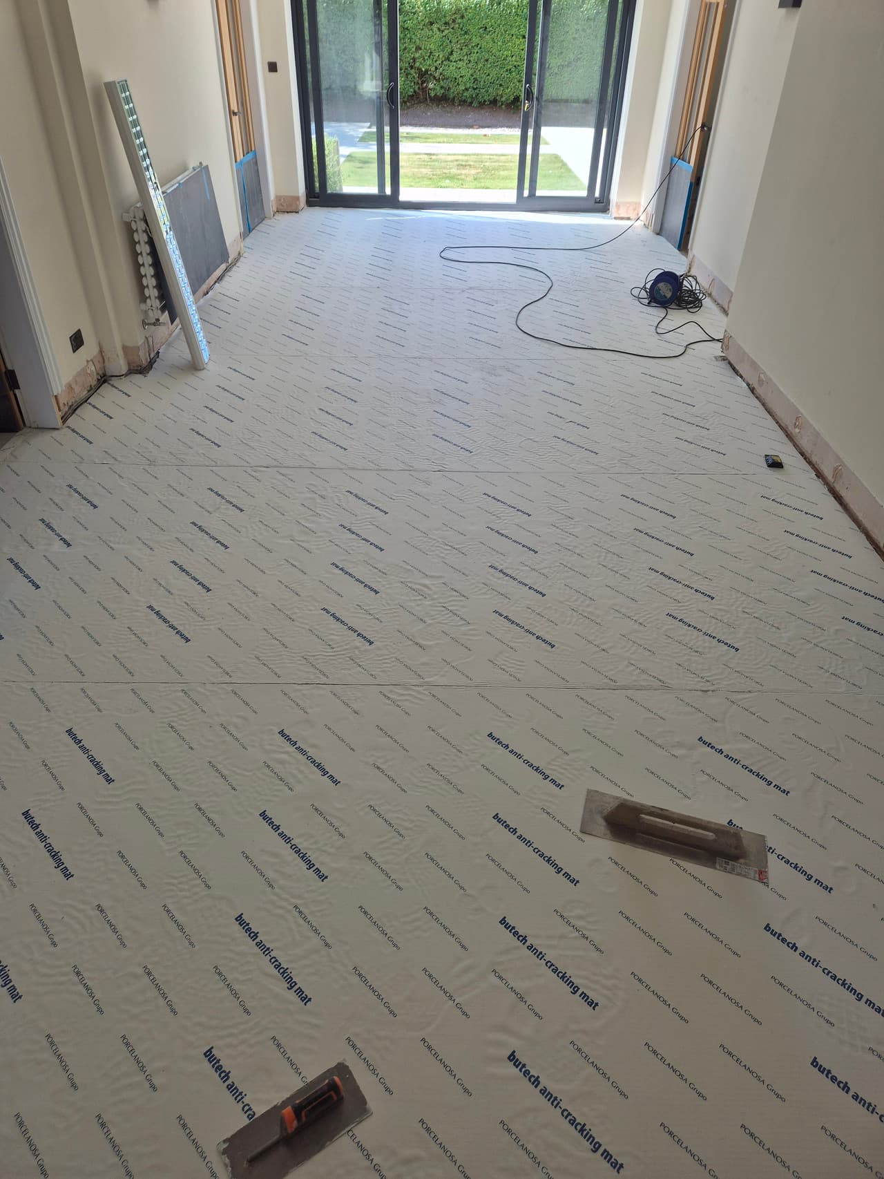 Anti-cracking decoupling membrane bonded across the whole floor before tiling