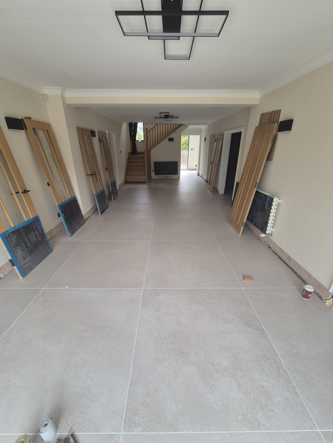 Completed continuous 1200x1200 porcelain floor running through the main ground-floor area to the garden bifolds, Oaklands Warrington